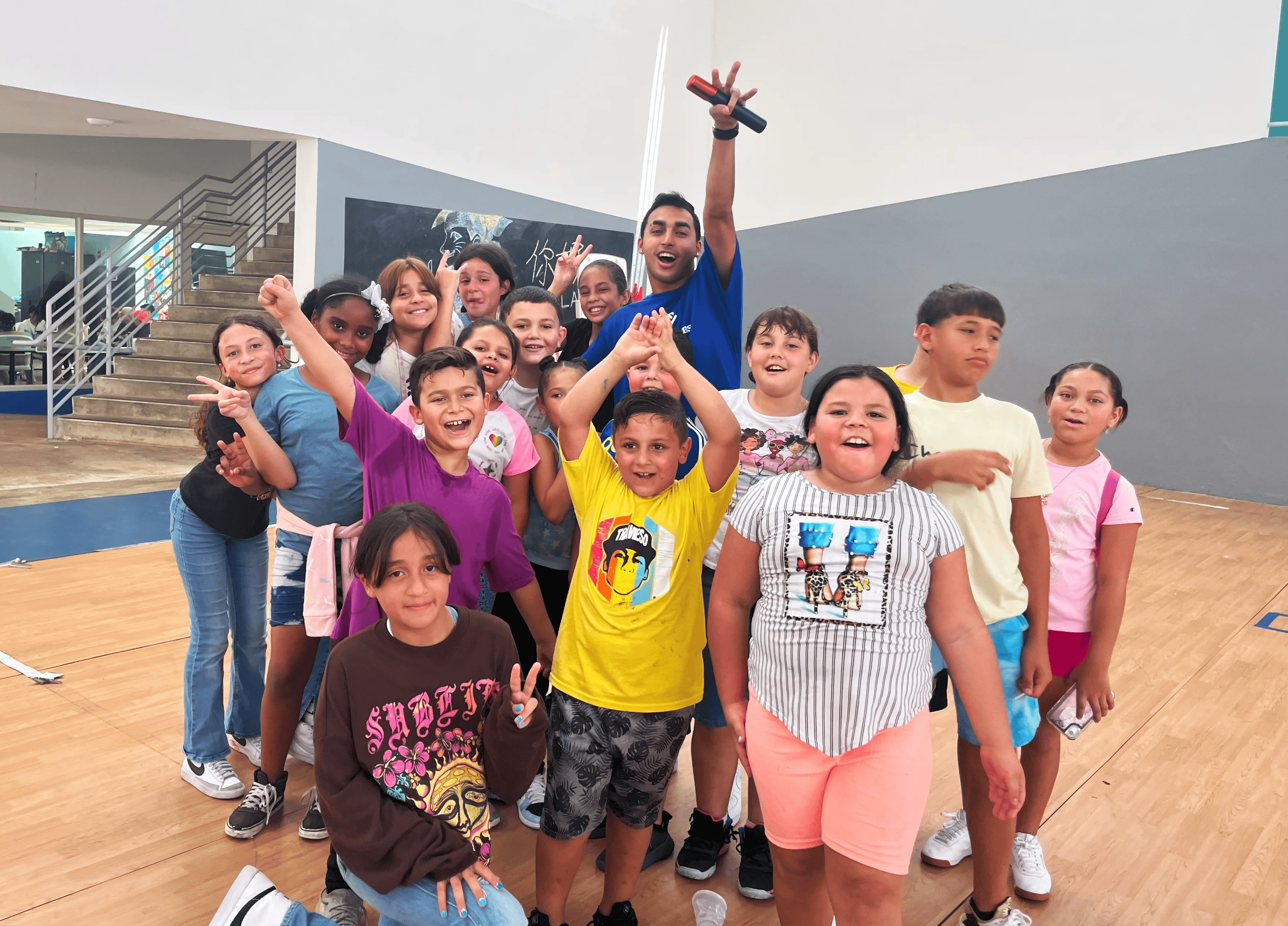 A group of youth pose for a photo in a gymnasium.