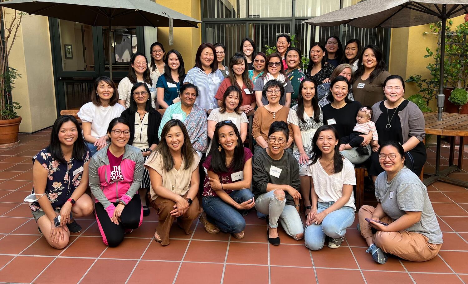 A group of about 20 people smiling at a group gathering