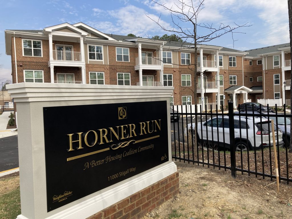 A brick apartment complex with a sign reading,"Horner Run, A Better Housing Coalition Community" 