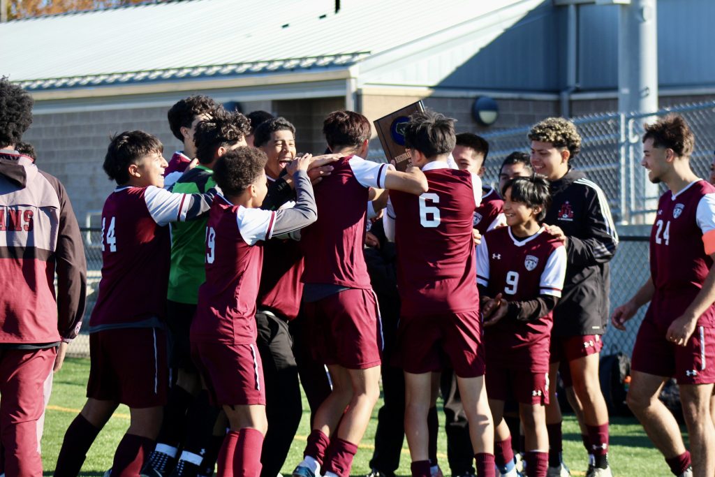 A group of Carmen soccer players cheering and celebrating their regional win.