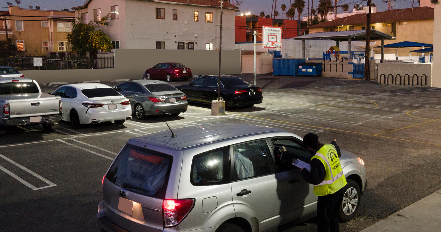 A volunteer speaks to the passenger of a motor vehicle