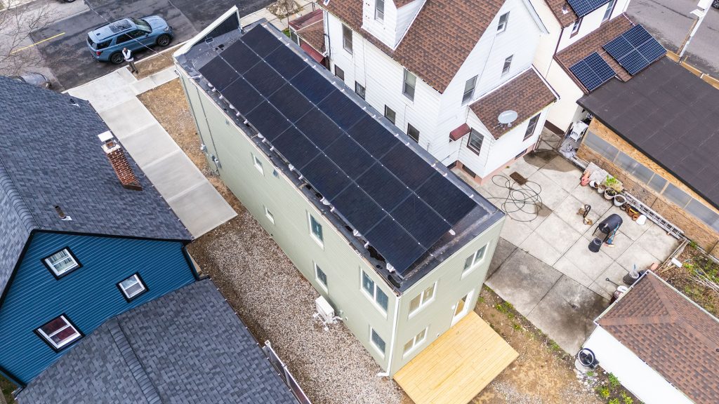 Arial view of several roofs with solar panels on several.