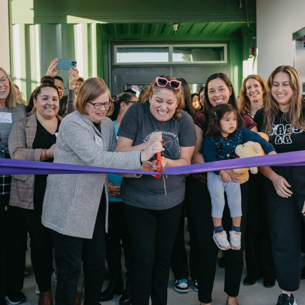 A group of a people cutting a ribbon