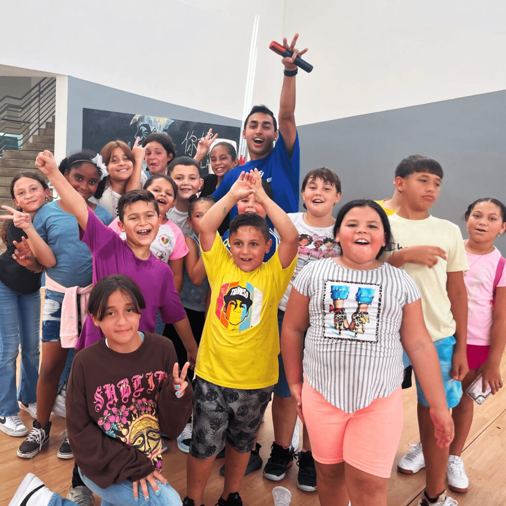 A group of children and a teacher smiling